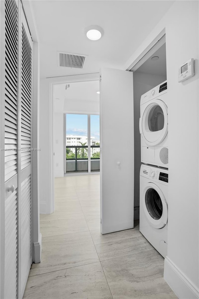 9261 E Bay Harbor Dr Unit 606, Bay Harbor Islands, FL 33154 - clothes washing area with light wood finished floors, laundry area, visible vents, baseboards, and stacked washer and dryer