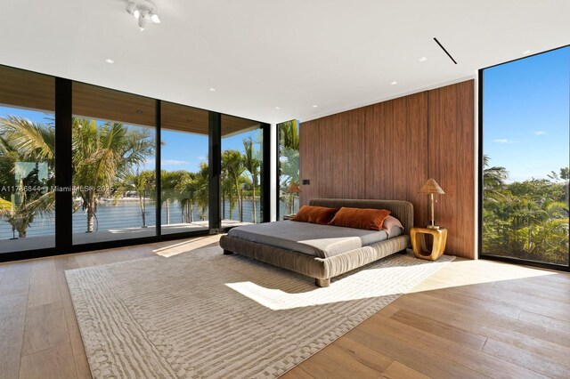 bedroom featuring wood finished floors, expansive windows, and multiple windows