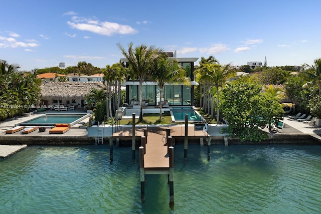 view of dock with an outdoor pool, an in ground hot tub, and a patio area