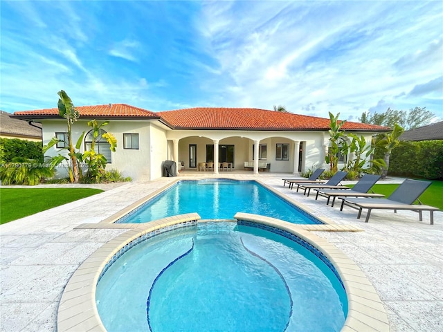 view of swimming pool with a patio and a pool with connected hot tub