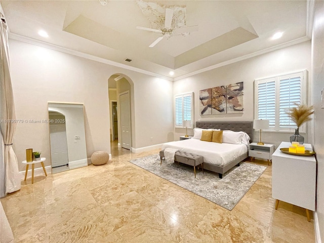bedroom featuring a raised ceiling, ornamental molding, and arched walkways