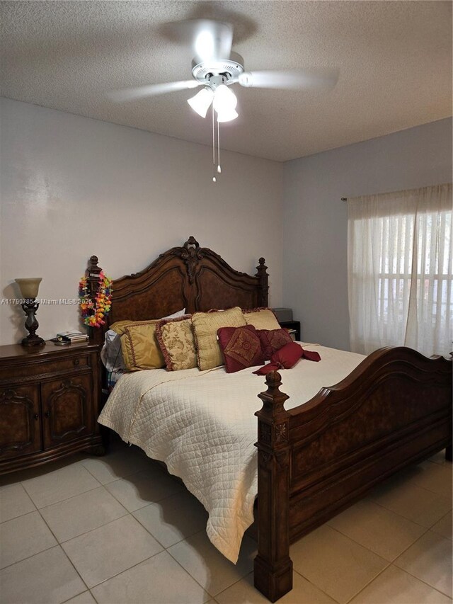 bedroom with light tile patterned floors, a textured ceiling, and ceiling fan