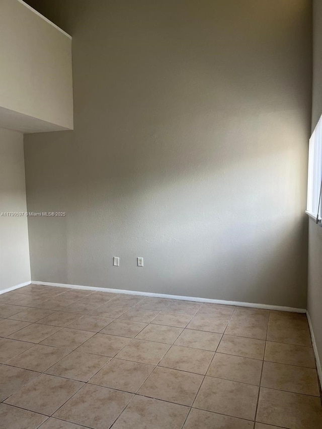 unfurnished room with baseboards and light tile patterned floors
