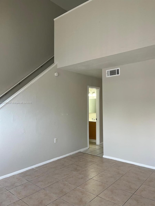 unfurnished room featuring light tile patterned floors, visible vents, and baseboards