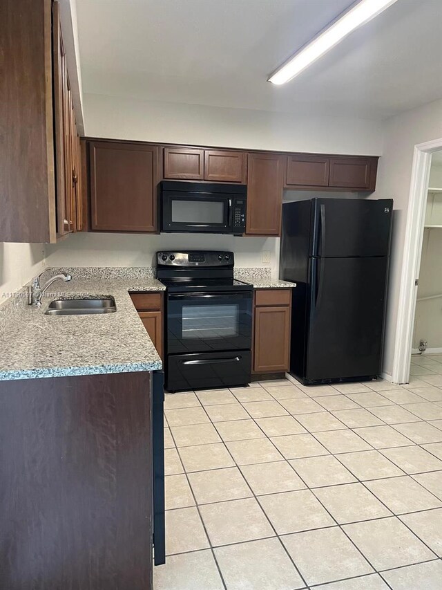 4002 Dolomite Unit A, Orlando, FL 32839 - kitchen with black appliances, a sink, light tile patterned floors, light stone counters, and dark brown cabinets