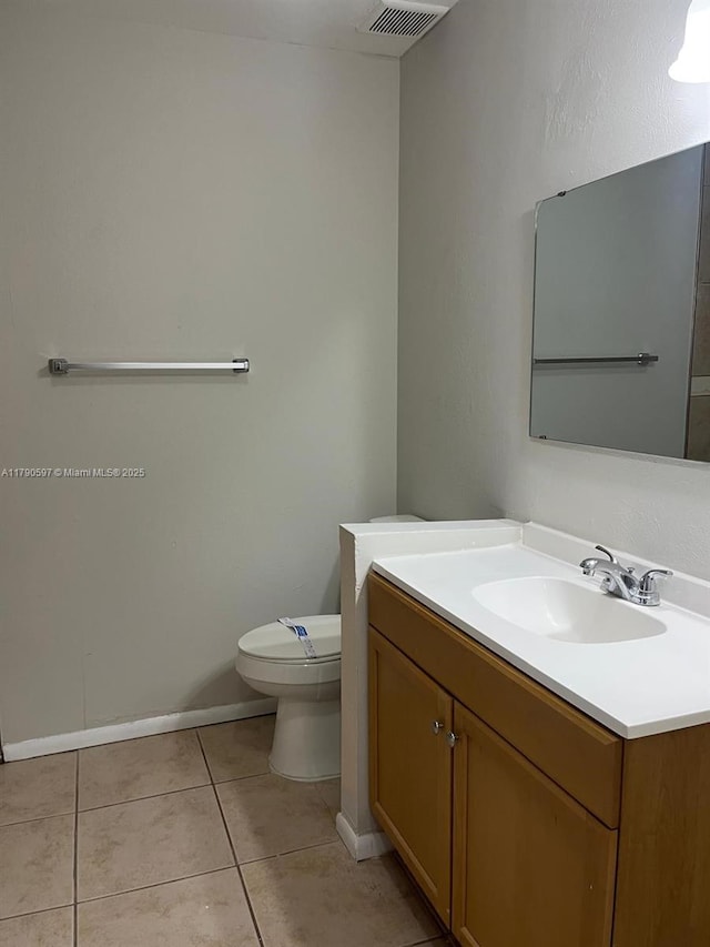 bathroom featuring toilet, visible vents, tile patterned floors, and baseboards