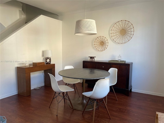 dining room featuring baseboards, wood finished floors, and ornamental molding
