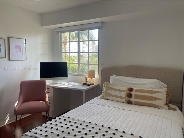 bedroom featuring baseboards and wood finished floors