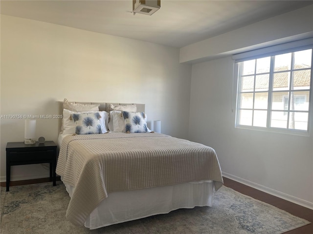 bedroom with baseboards and wood finished floors