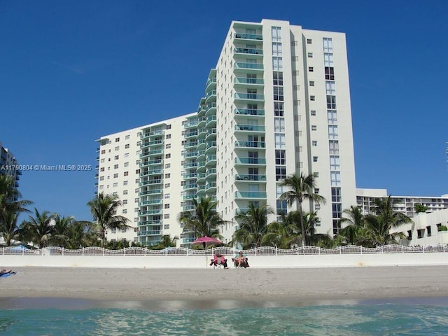 view of building exterior with a water view and a view of the beach