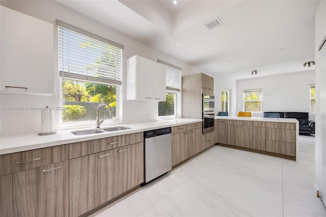 3648 Oak Ave, Coconut Grove, FL 33133 - kitchen with visible vents, a peninsula, light countertops, a sink, and appliances with stainless steel finishes
