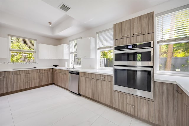 3648 Oak Ave, Coconut Grove, FL 33133 - kitchen with a sink, light countertops, stainless steel appliances, visible vents, and modern cabinets