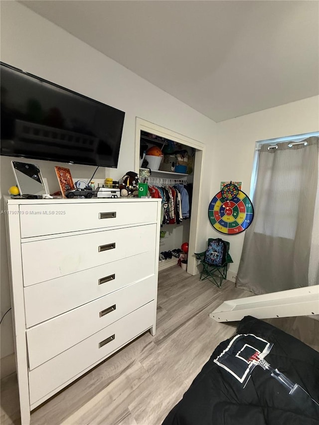 bedroom with light wood-style floors and a closet
