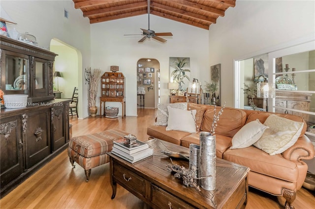 living area with arched walkways, high vaulted ceiling, and wooden ceiling