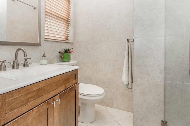 bathroom with tile walls, tile patterned floors, toilet, and vanity
