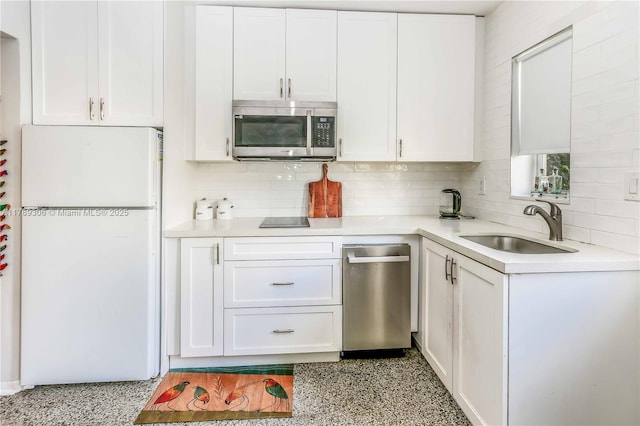 kitchen featuring white cabinetry, stainless steel appliances, backsplash, and a sink