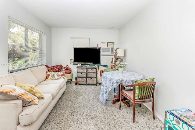 living area featuring speckled floor and baseboards