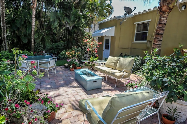view of patio / terrace featuring an outdoor living space with a fire pit and outdoor dining area