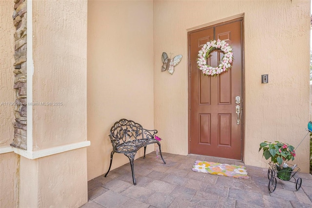 entrance to property with stucco siding