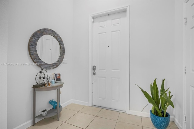 foyer featuring light tile patterned flooring and baseboards