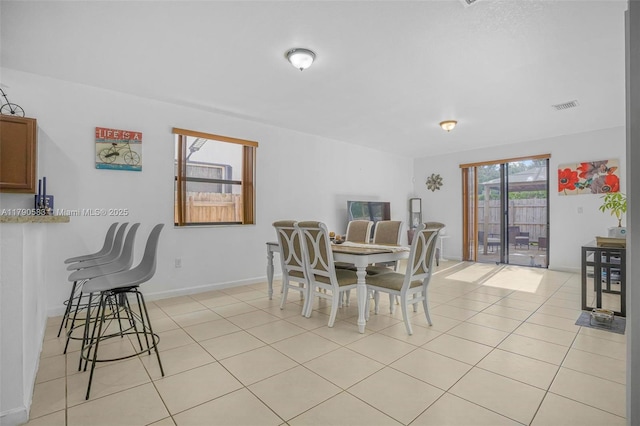 dining space with light tile patterned floors, visible vents, and baseboards
