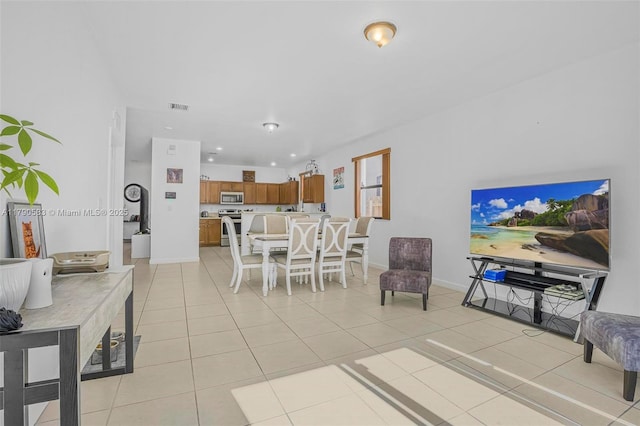 living area featuring baseboards, visible vents, light tile patterned flooring, and recessed lighting