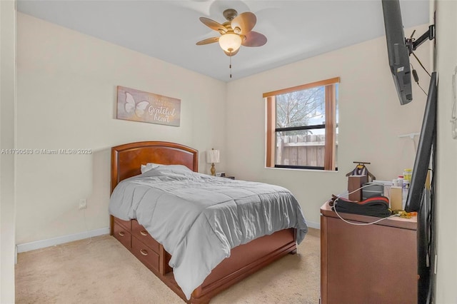 bedroom featuring a ceiling fan, light colored carpet, and baseboards