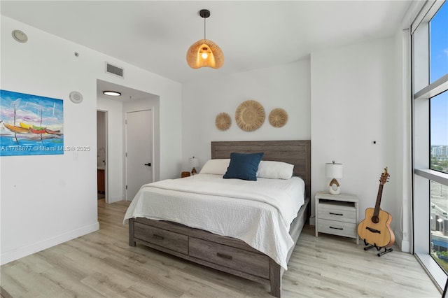 bedroom featuring visible vents, light wood-style flooring, and baseboards