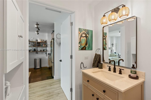 bathroom with vanity, visible vents, and wood finished floors
