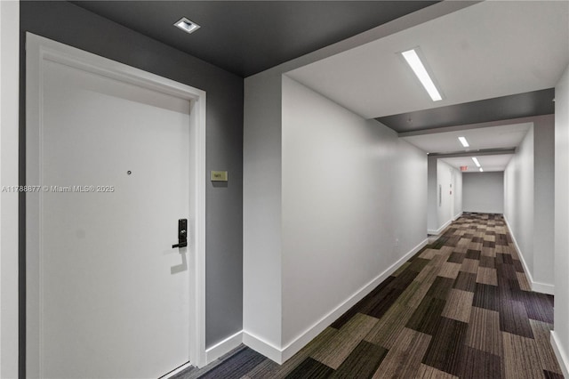 hall with baseboards and dark wood-type flooring