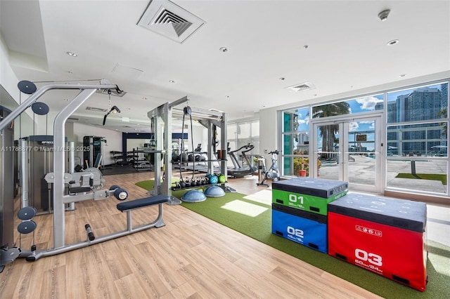 gym with wood finished floors, visible vents, and french doors