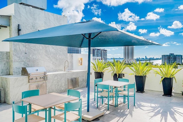 view of patio featuring outdoor dining area, area for grilling, and a sink