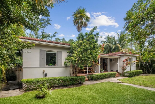 11105 NE 9th Ave, Biscayne Park, FL 33161 - view of front of house with stucco siding, a tiled roof, a front yard, and fence