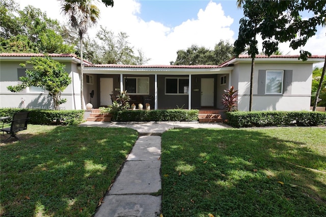 11105 NE 9th Ave, Biscayne Park, FL 33161 - ranch-style house with covered porch, a tile roof, a front yard, and stucco siding