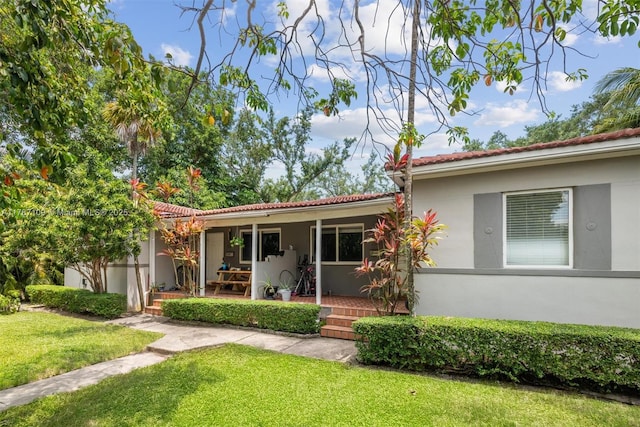 11105 NE 9th Ave, Biscayne Park, FL 33161 - exterior space with stucco siding, a yard, and a tile roof
