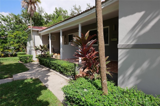 11105 NE 9th Ave, Biscayne Park, FL 33161 - view of side of property featuring a porch, stucco siding, a yard, and a tile roof