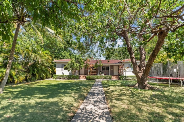 11105 NE 9th Ave, Biscayne Park, FL 33161 - single story home featuring a front yard, a trampoline, and stucco siding