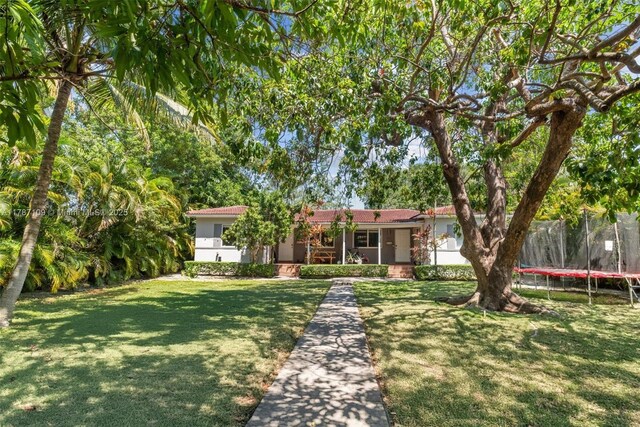 11105 NE 9th Ave, Biscayne Park, FL 33161 - single story home featuring a front yard, a trampoline, and stucco siding