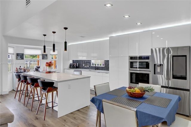 kitchen featuring white cabinetry, stainless steel appliances, modern cabinets, and a center island