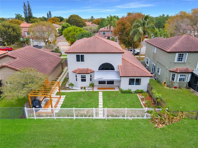 back of property with a tile roof, a residential view, a yard, a fenced backyard, and stucco siding