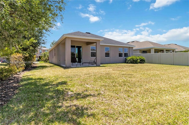 10860 79th St, E, FL 34219 - back of property featuring stucco siding, fence, and a lawn