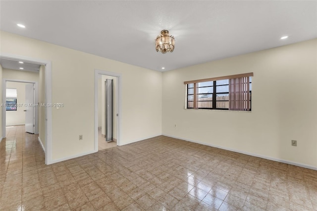 spare room with recessed lighting, an inviting chandelier, and baseboards