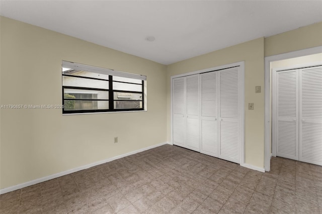 unfurnished bedroom with a closet and baseboards