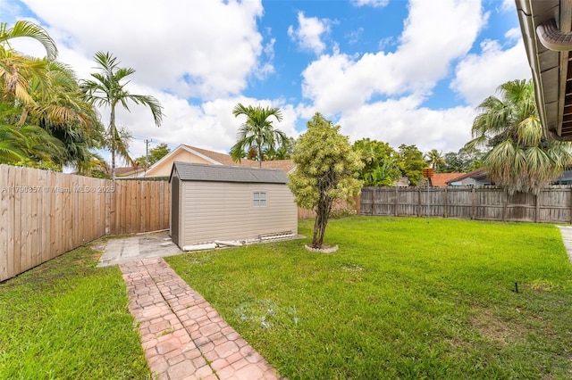 view of yard featuring an outbuilding, a shed, and a fenced backyard