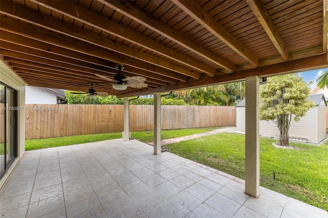 view of patio / terrace with an outdoor structure, a storage unit, ceiling fan, and a fenced backyard