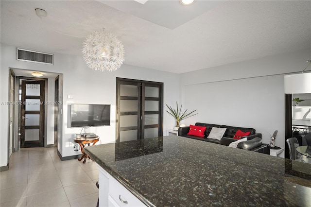 901 S Surf Rd Unit 603, Hollywood, FL 33019 - kitchen featuring visible vents, light tile patterned floors, dark stone countertops, an inviting chandelier, and white cabinetry