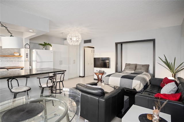 901 S Surf Rd Unit 603, Hollywood, FL 33019 - bedroom featuring visible vents, freestanding refrigerator, a textured ceiling, and an inviting chandelier