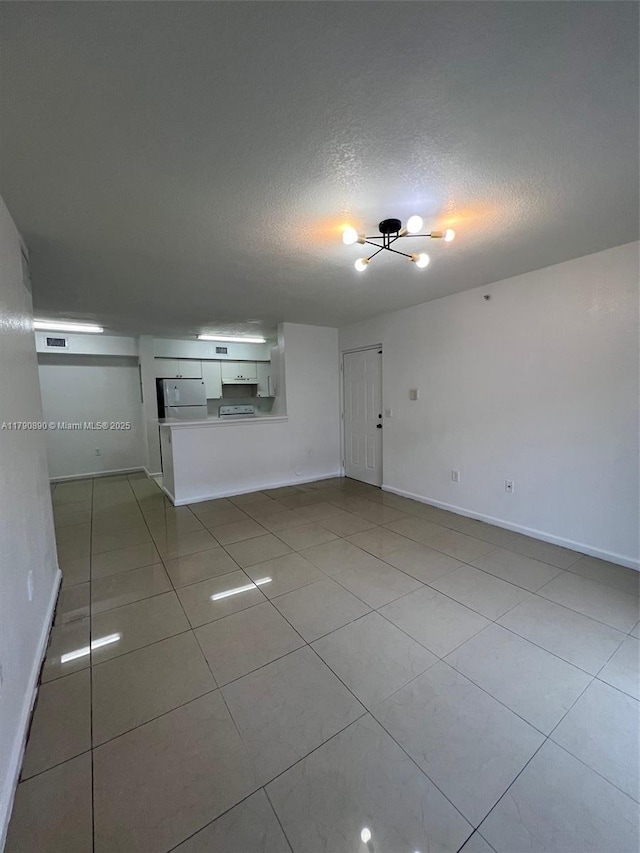 15422 SW 284th St Unit 7104, Homestead, FL 33033 - empty room featuring a chandelier, a textured ceiling, and light tile patterned floors