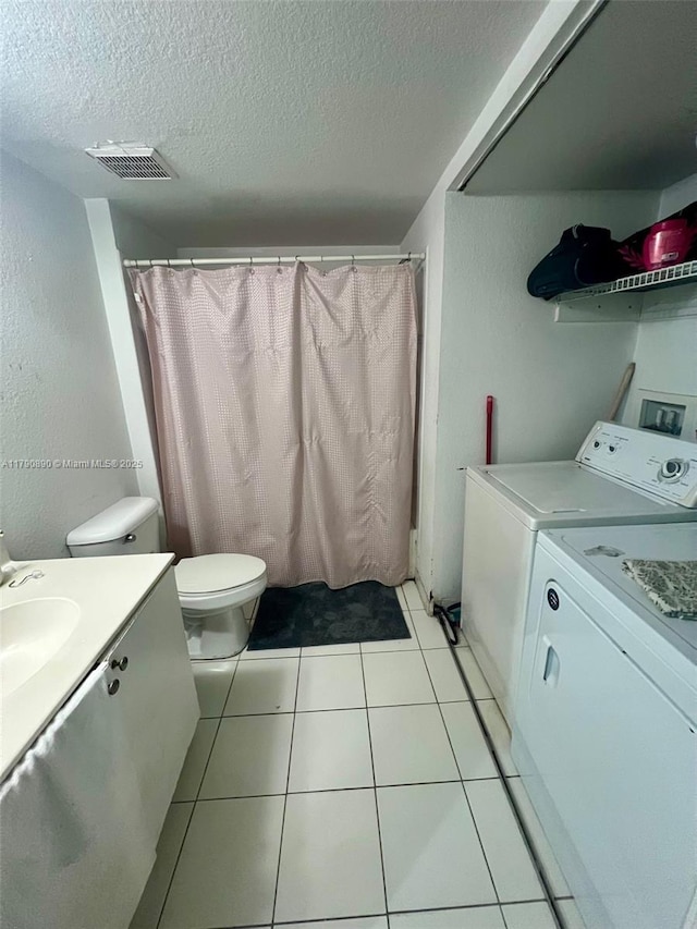 full bathroom featuring a textured ceiling, visible vents, washing machine and clothes dryer, and vanity