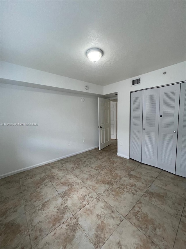 15422 SW 284th St Unit 7104, Homestead, FL 33033 - unfurnished bedroom featuring a closet, a textured ceiling, and tile patterned floors